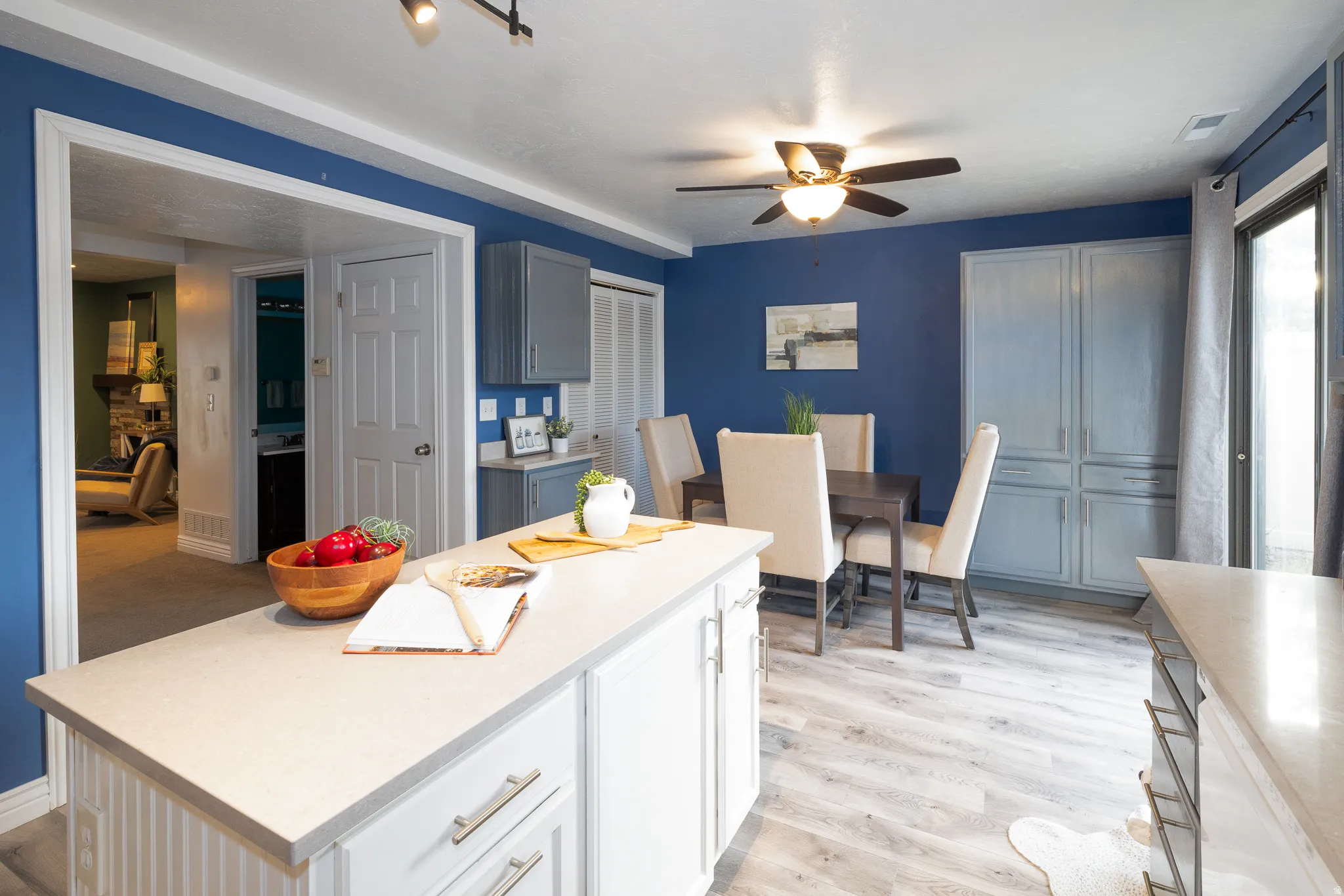 Kitchen island with light-toned countertop and white paneled base