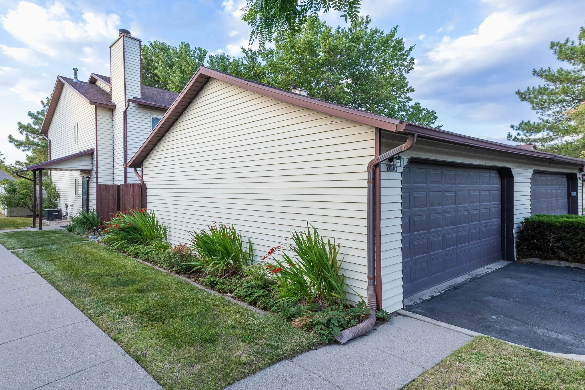 Light-toned siding exterior featuring a multi-car garage with paneled garage doors