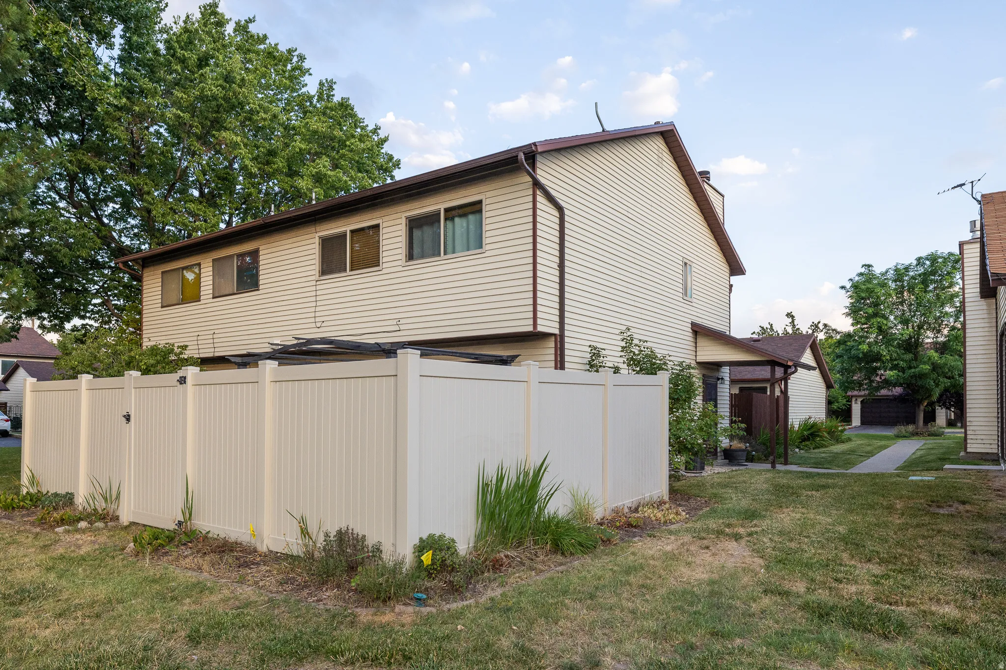 Cream-colored siding exterior with brown trim and roofline
