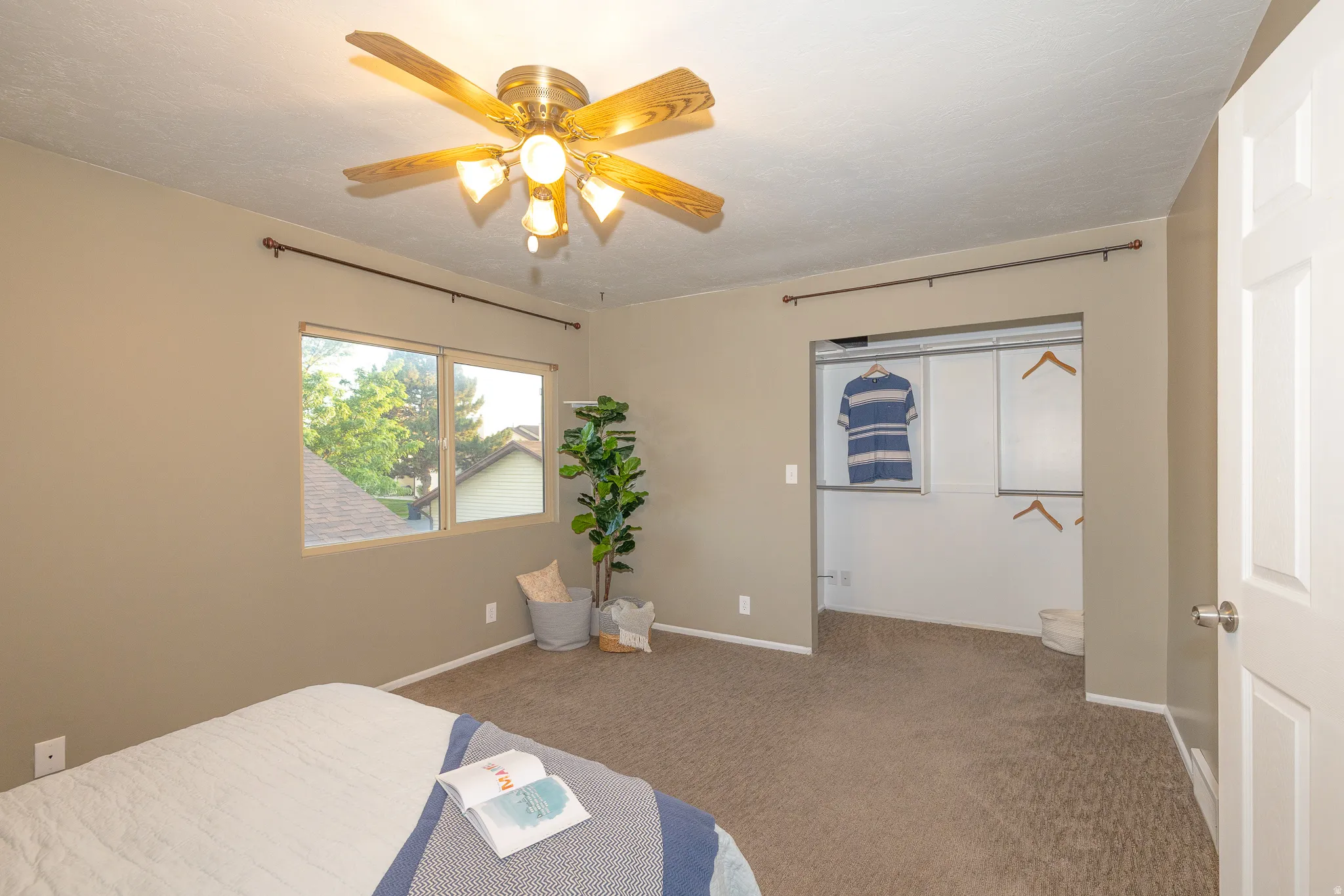 Carpeted room featuring a ceiling fan with light fixture, double-paned window, and a built-in closet with sliding doors
