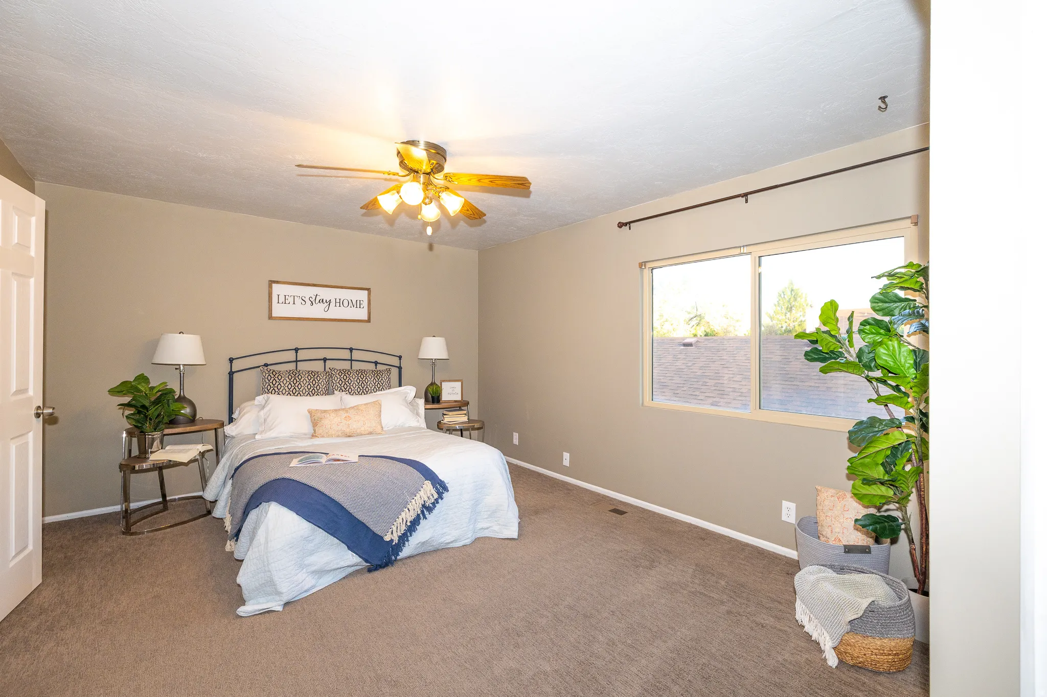 Carpeted room featuring a ceiling fan, dual windows with a dark rod, and neutral wall paint
