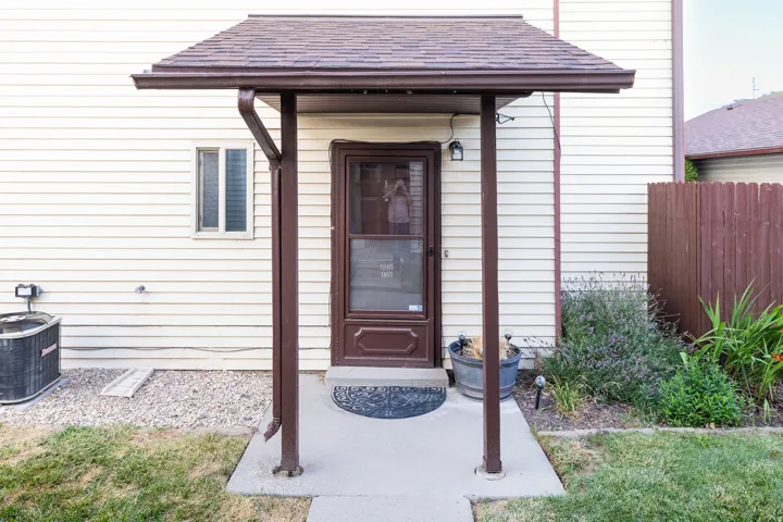 Covered entry with asphalt shingle roof and brown gutter system