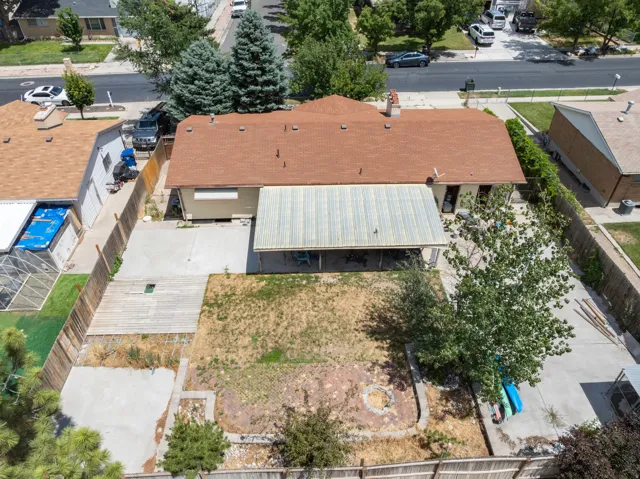 Expansive backyard featuring a large concrete patio, a covered patio area, and a dedicated fire pit space