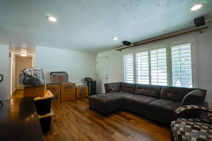 Spacious interior room featuring wood-finish flooring, recessed lighting, and white walls