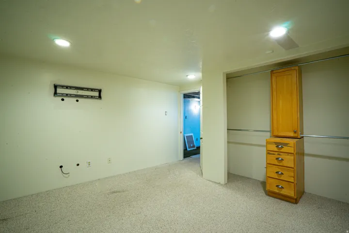 Spacious interior room featuring light-toned carpet flooring and recessed ceiling lighting