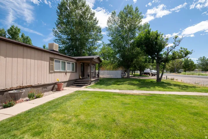 Well-maintained front lawn and walkway leading to a covered porch entrance