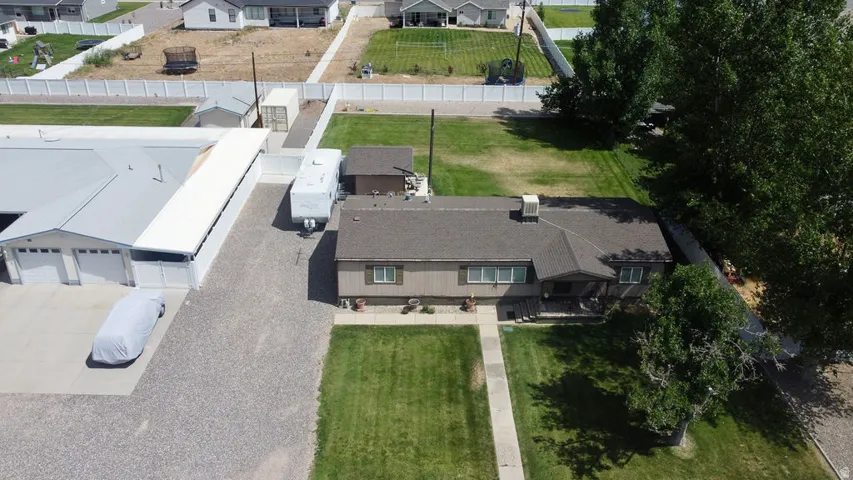 Expansive gravel driveway leading to a multi-bay garage with overhead doors