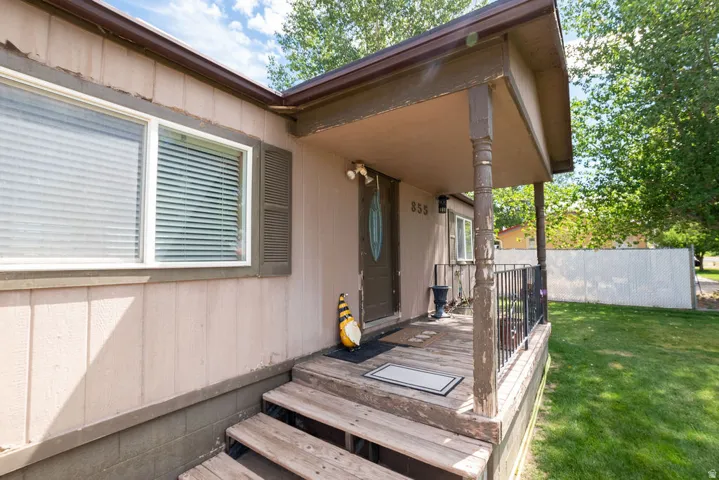 Front porch entrance featuring wood steps and a covered patio area