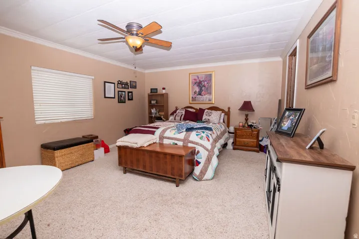 Spacious room featuring neutral-toned walls, textured ceiling, crown molding, and light-colored carpeting