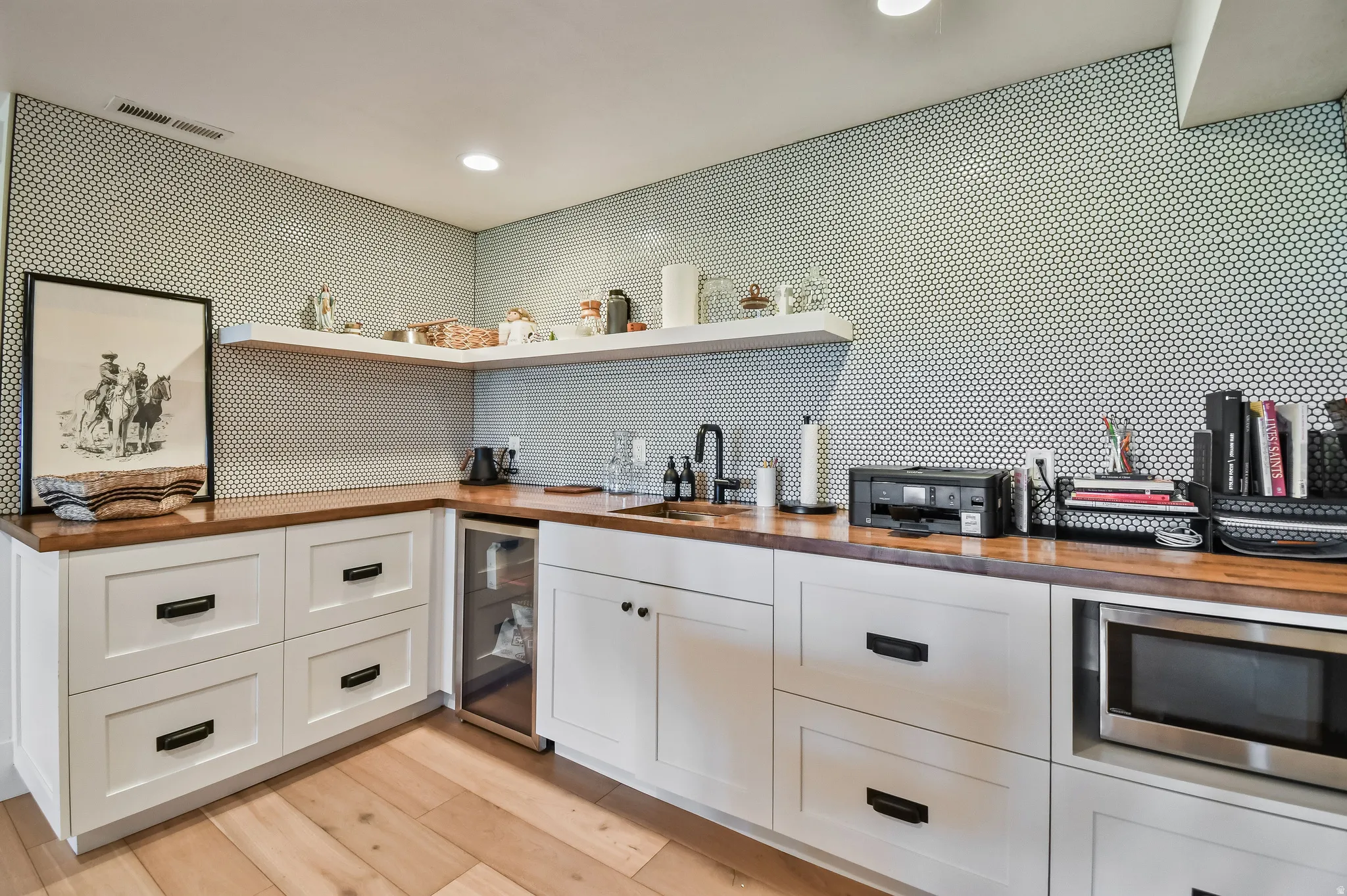 Kitchenette featuring white shaker-style cabinetry, wood-finish countertops, and a full-height penny tile backsplash