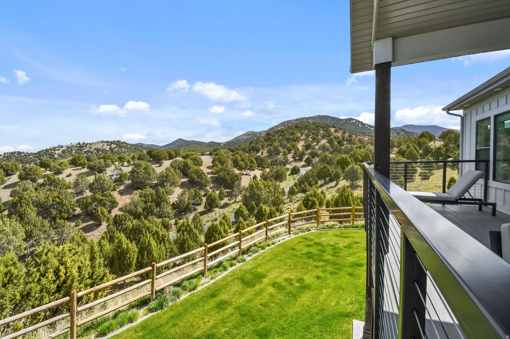 Covered deck featuring a wood-finish floor and contemporary cable railings