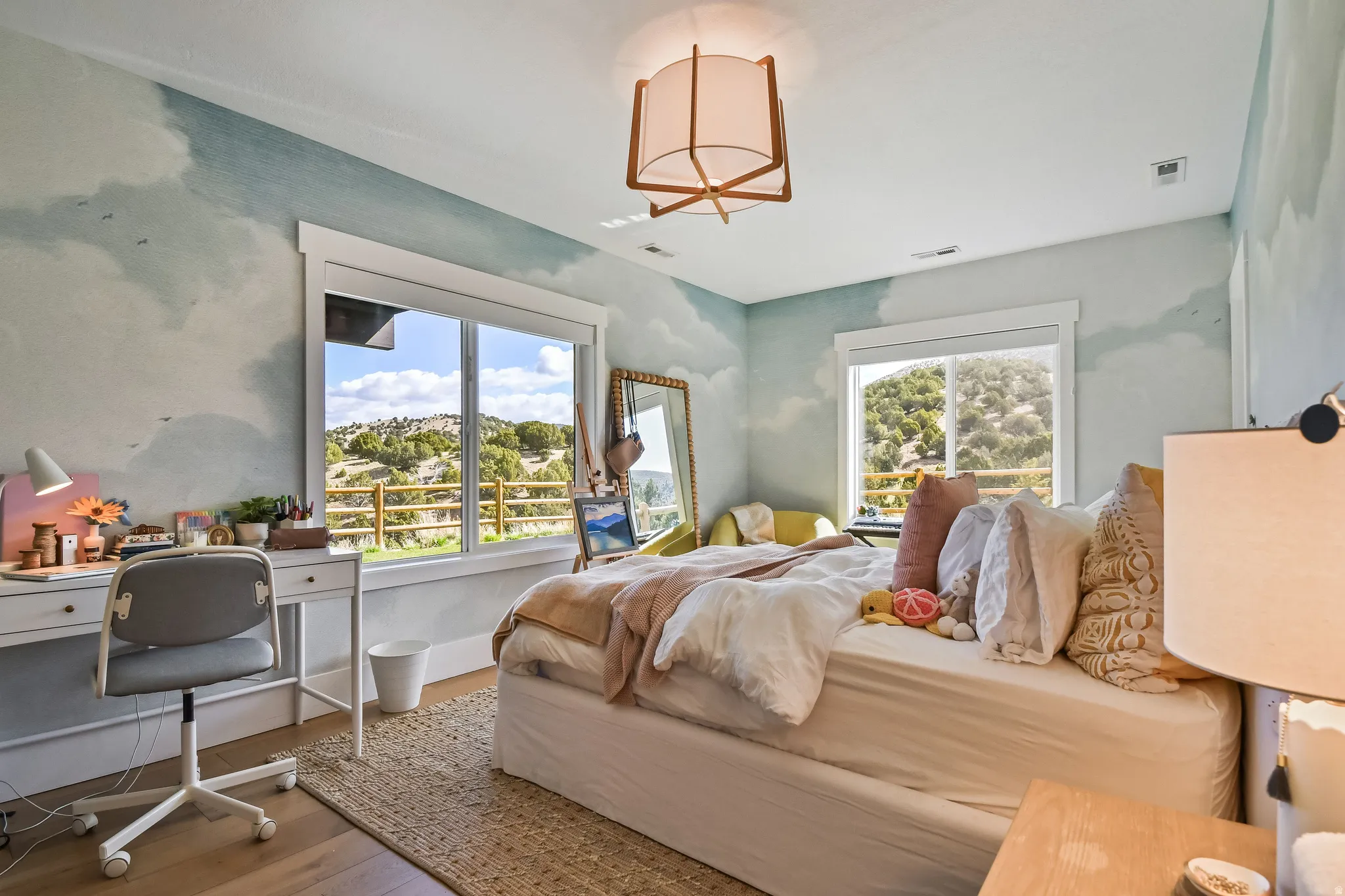 Hardwood-style flooring throughout this room with two large windows offering abundant natural light and scenic outdoor topography