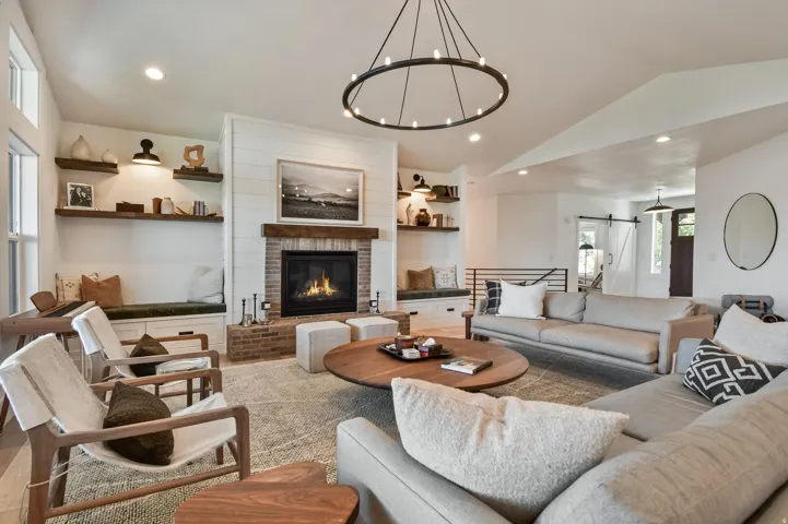 Spacious living area featuring a brick fireplace with wood mantle, built-in bench seating with storage, and integrated shelving