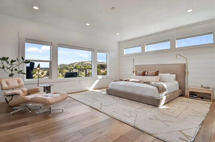 Primary Bedroom featuring wide plank wood-finish flooring, recessed lighting, and expansive windows