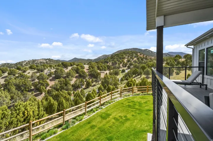 Covered deck featuring a wood-finish floor and contemporary cable railings