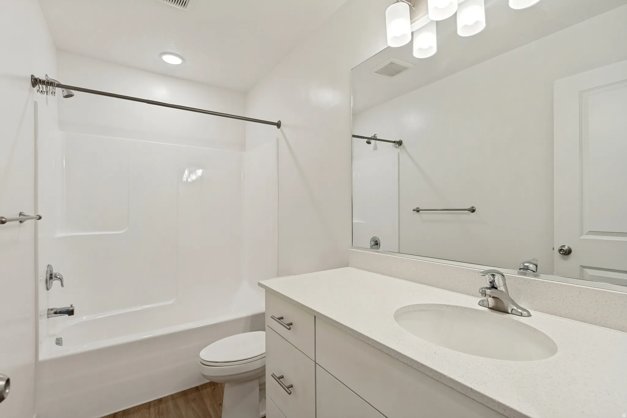 Bathroom two featuring a white vanity with an undermount sink, a light-colored countertop, and chrome hardware