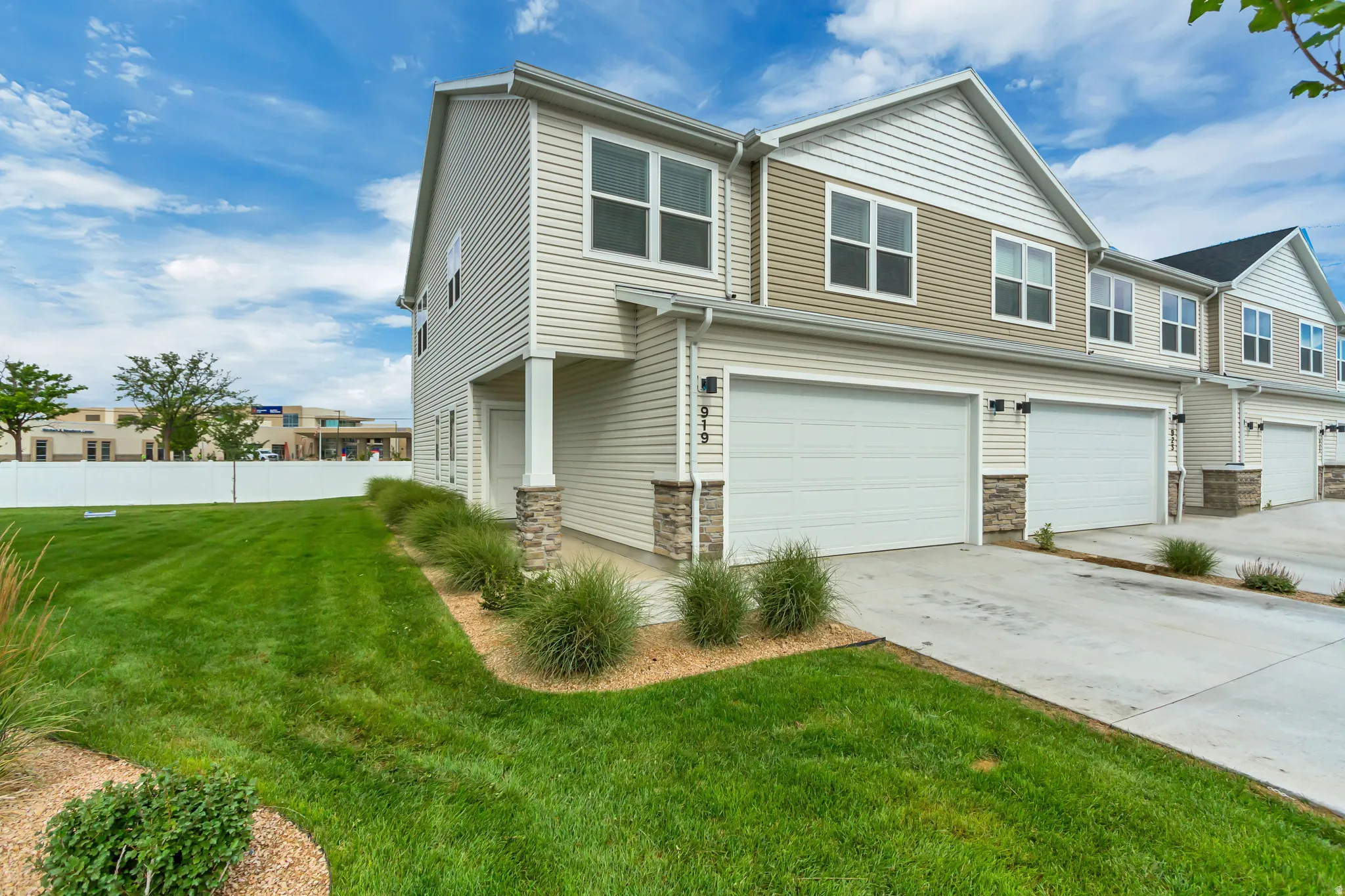 Modern townhome exterior featuring concrete driveway, and stone accents
