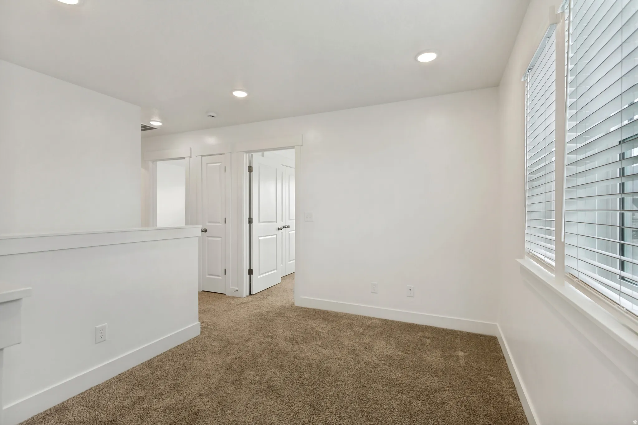 Loft featuring white walls, recessed lighting