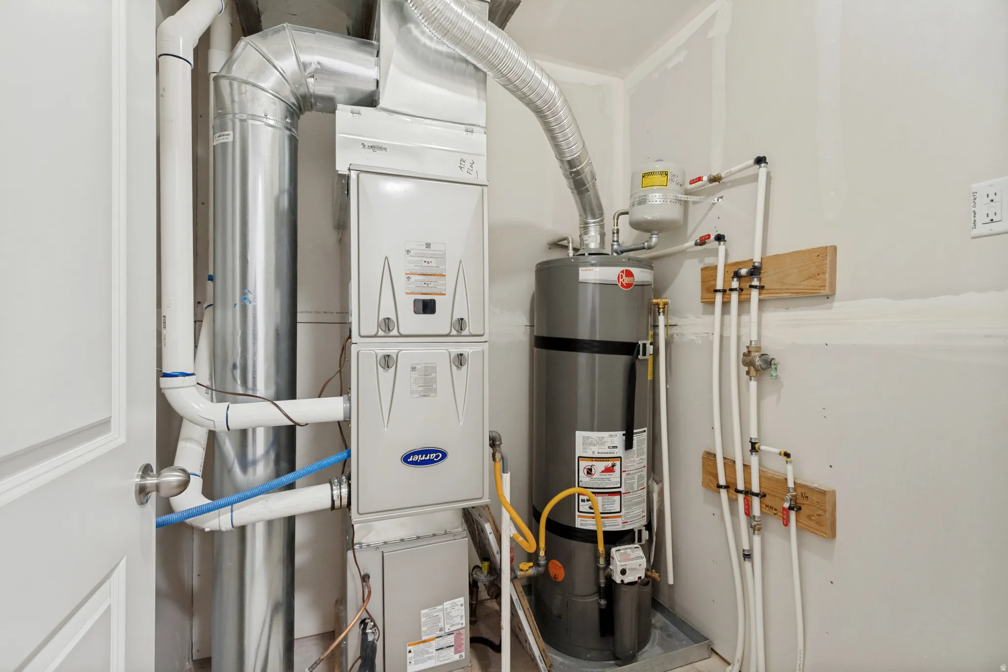 Dedicated utility area featuring a Carrier furnace system, Rheem water heater, and organized plumbing with PEX piping