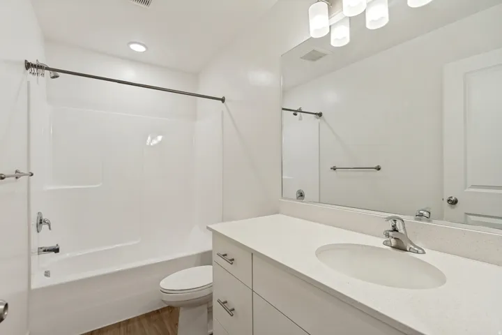 Bathroom two featuring a white vanity with an undermount sink, a light-colored countertop, and chrome hardware
