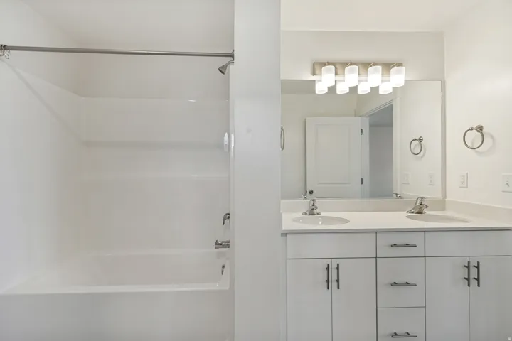 Mast bathroom featuring a double vanity with matching quartz countertops