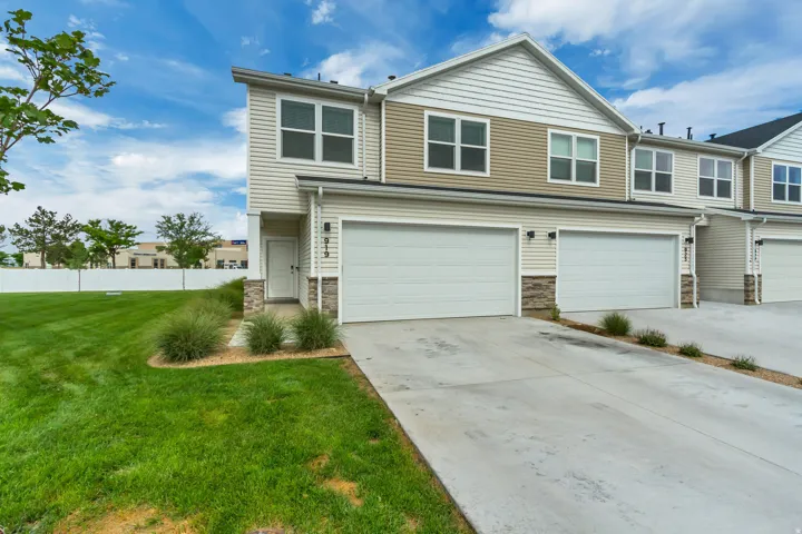 Modern townhome exterior featuring concrete driveway, and stone accents