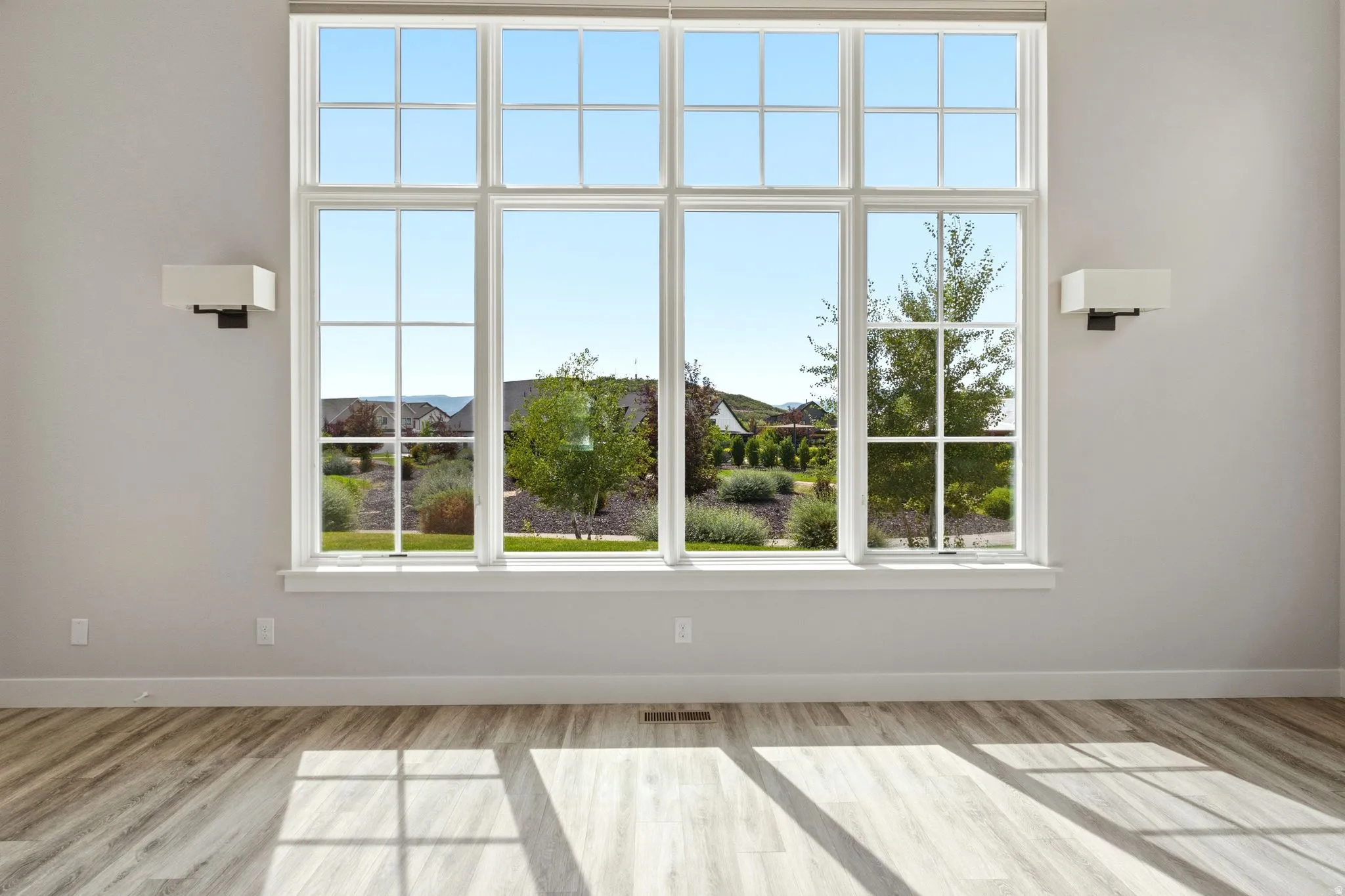 Expansive multi-pane window with white trim and a surrounding landscaped exterior