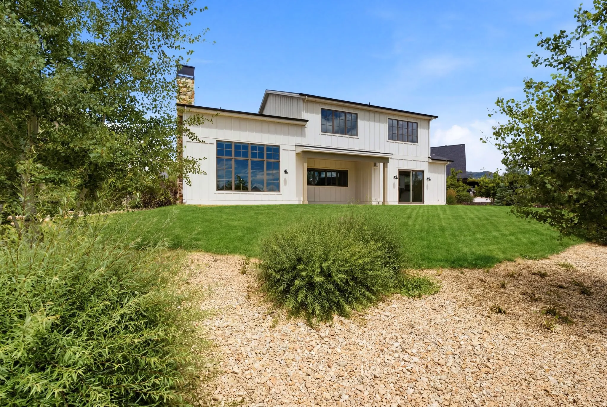 Contemporary two-story exterior with white vertical siding and dark-trimmed windows