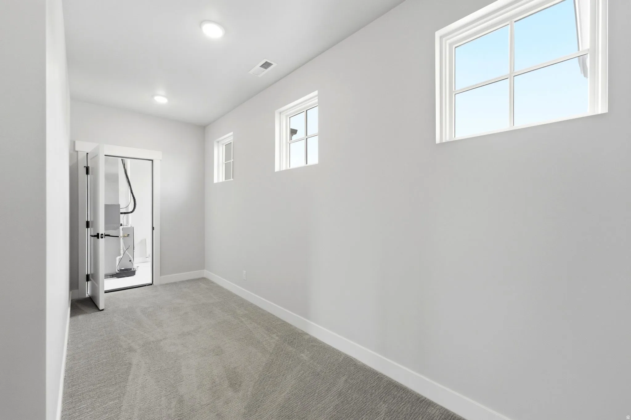 Room featuring gray carpeting, white baseboards, and light gray wall paint