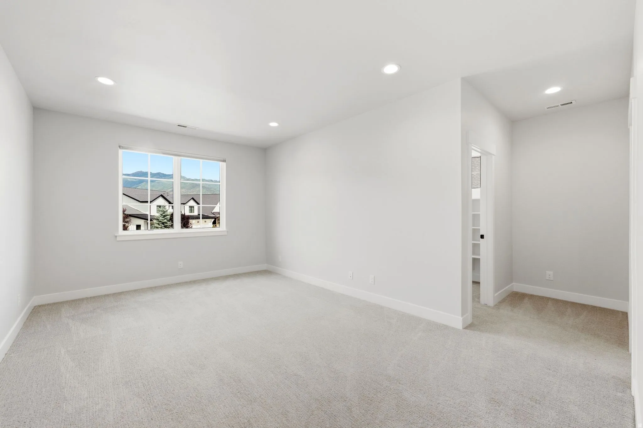 Spacious interior room with light neutral carpet and white trim