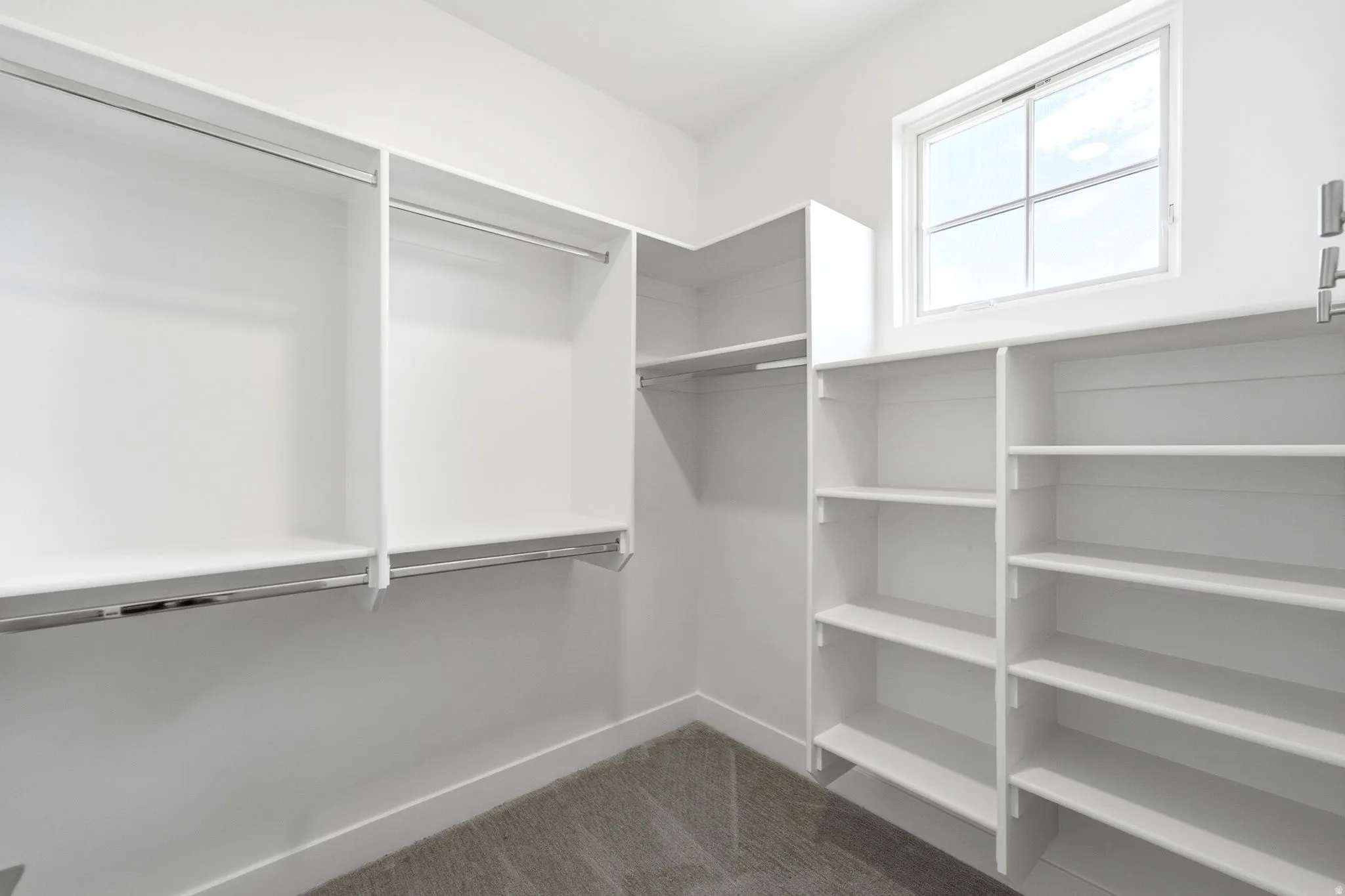 Custom closet system featuring white shelving and chrome hanging rods