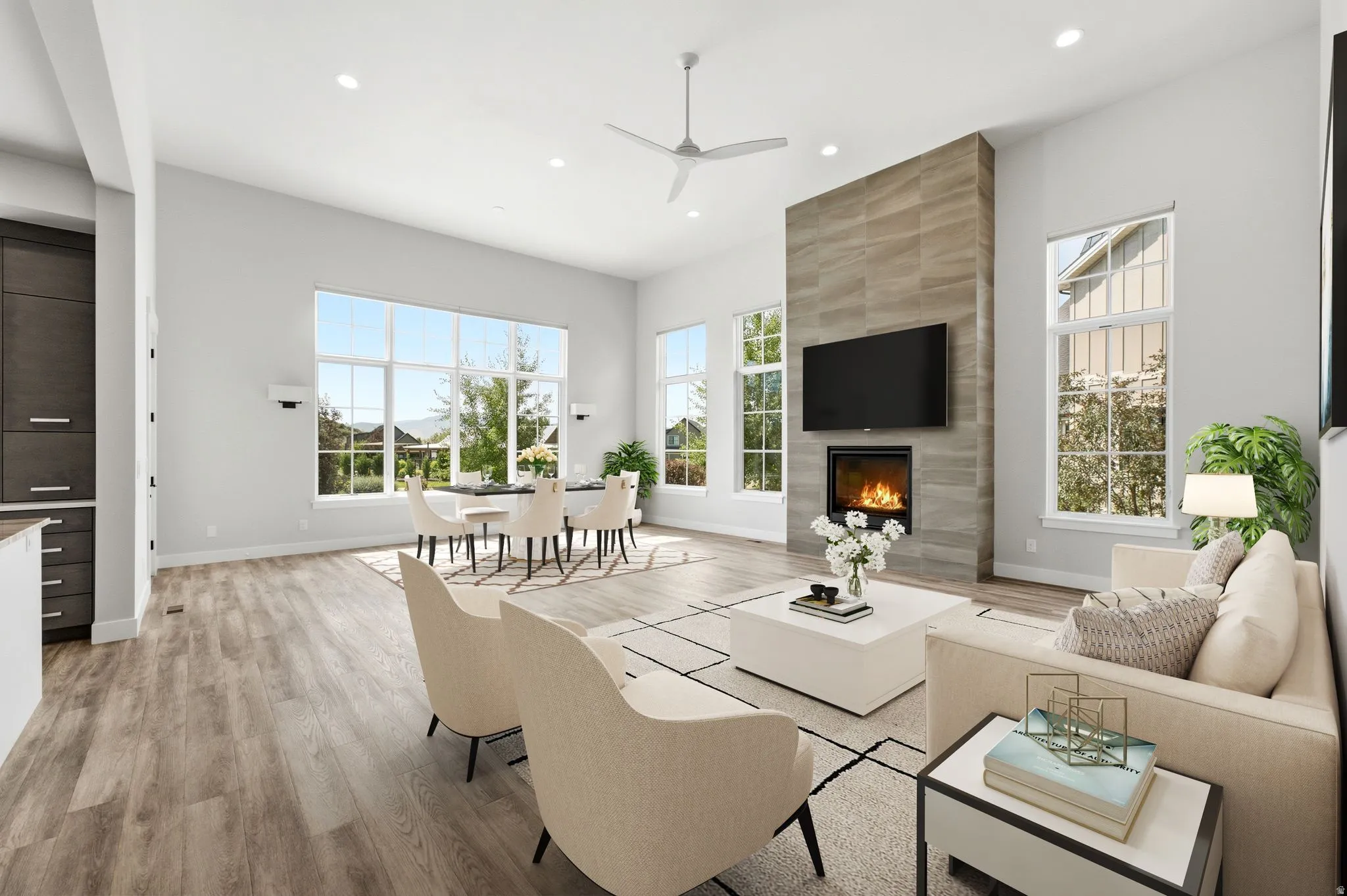 Spacious living area featuring wood-finish flooring, a contemporary fireplace with a tiled surround, and expansive windows