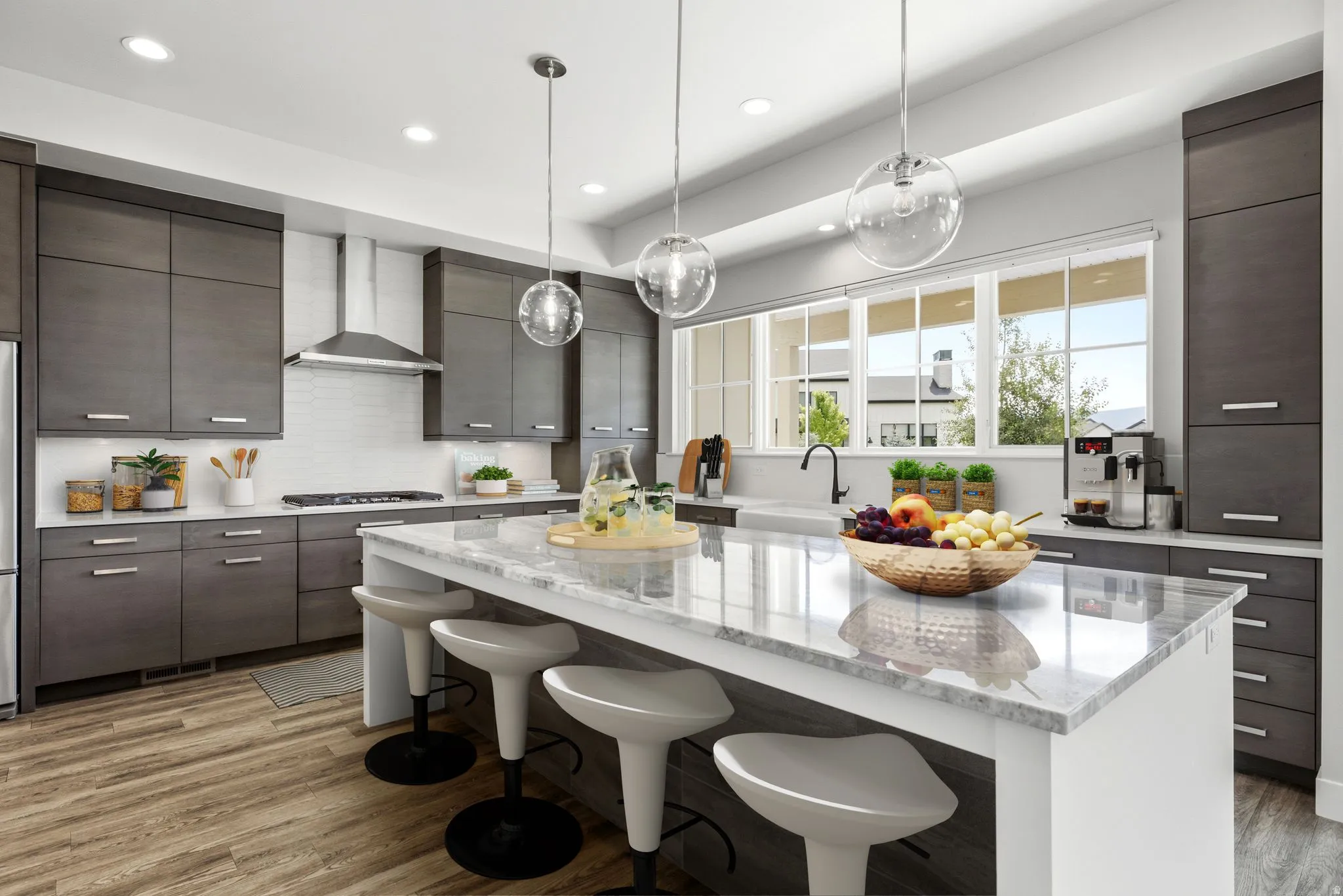 Kitchen featuring a large island with a stone countertop, wood-finish flooring, dark wood cabinetry, white subway tile backsplash, and stainless steel appliances