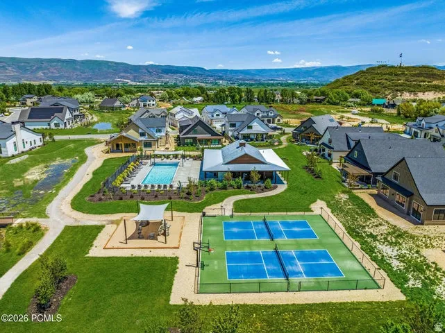Community amenities featuring a swimming pool, clubhouse, two pickleball courts, and a shaded gathering area