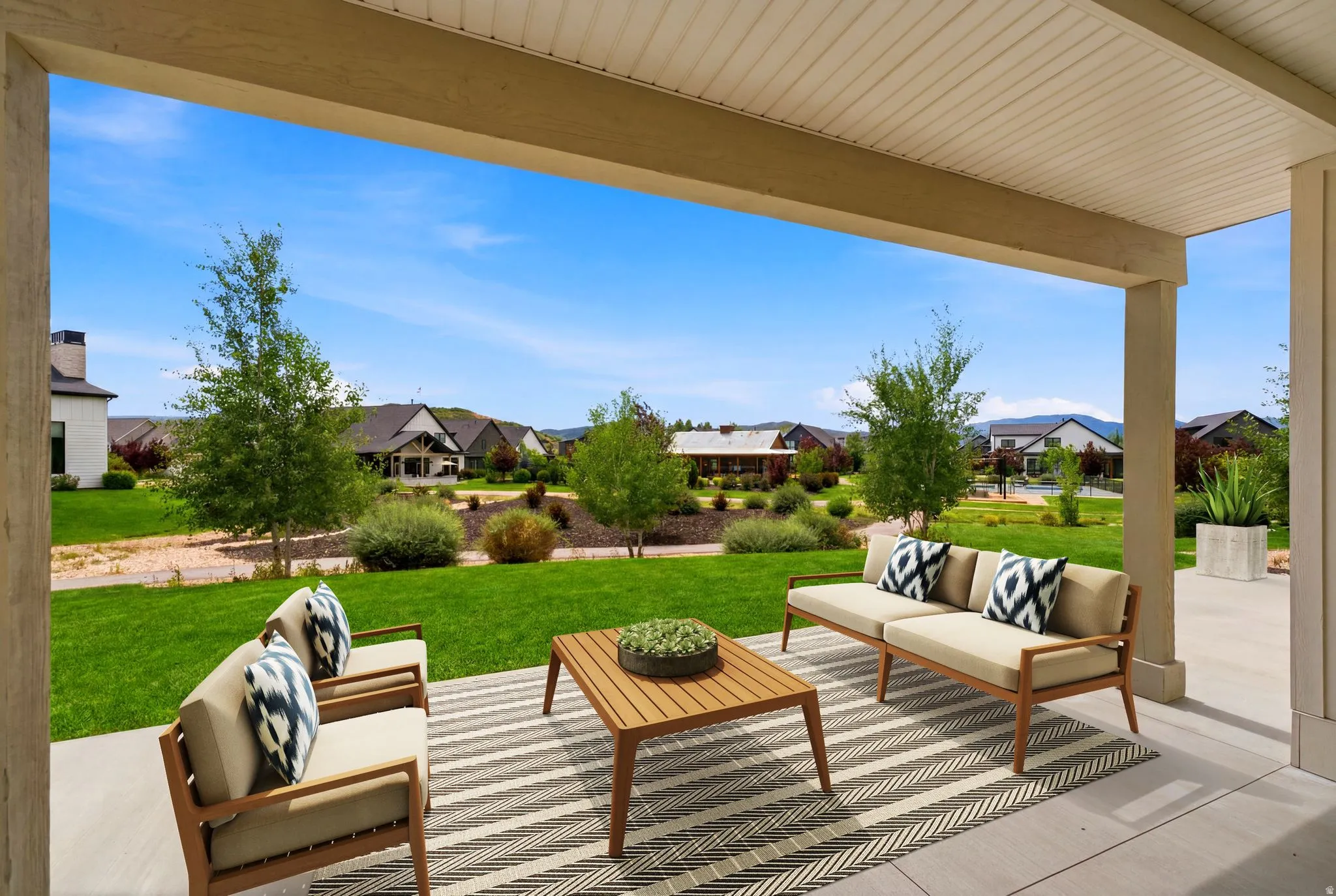 Covered patio with concrete flooring, supported by substantial pillars