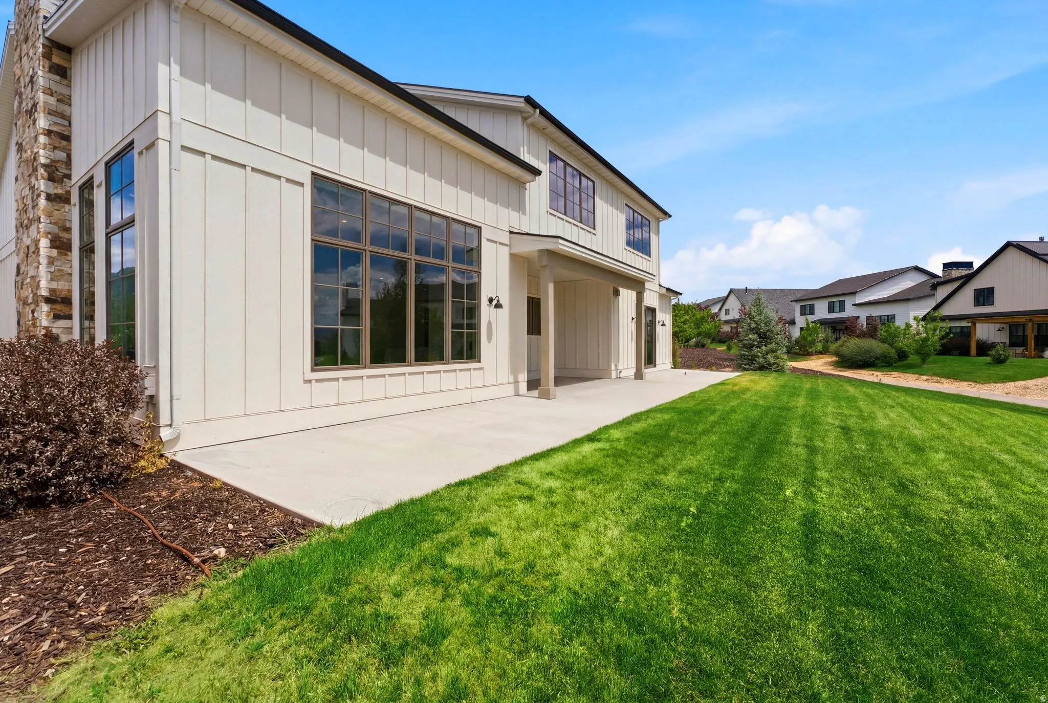 Modern board and batten exterior with a stone chimney accent