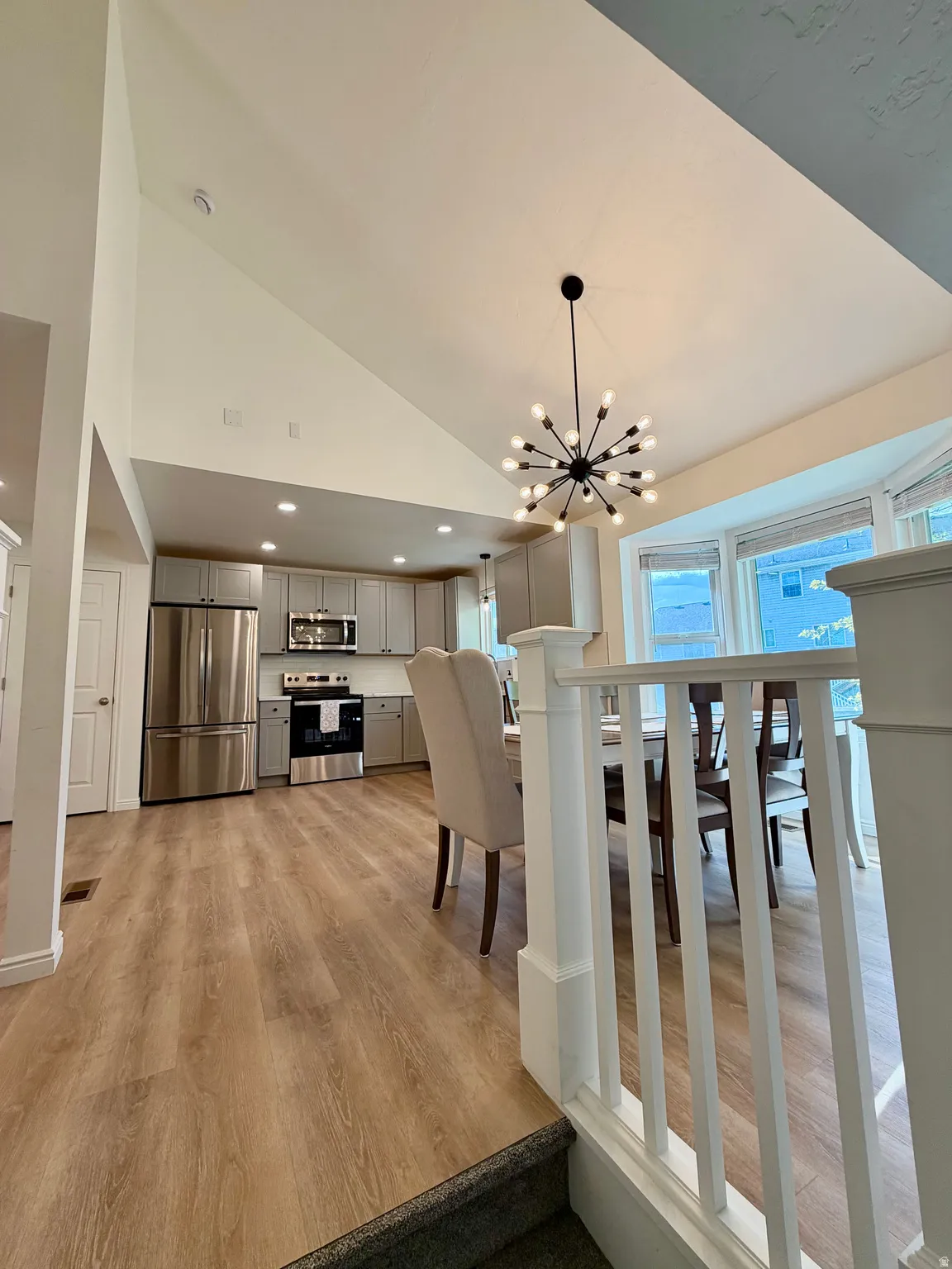 Vaulted ceilings with recessed lighting and a contemporary chandelier