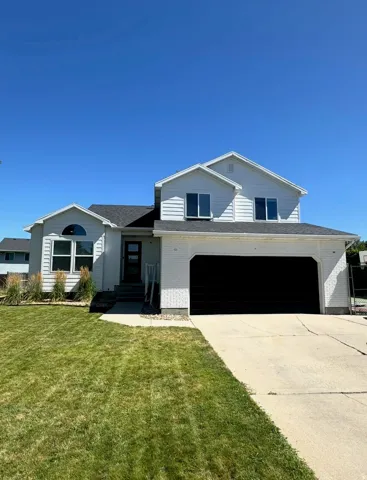 Two-story residence featuring white siding and a black shingle roof