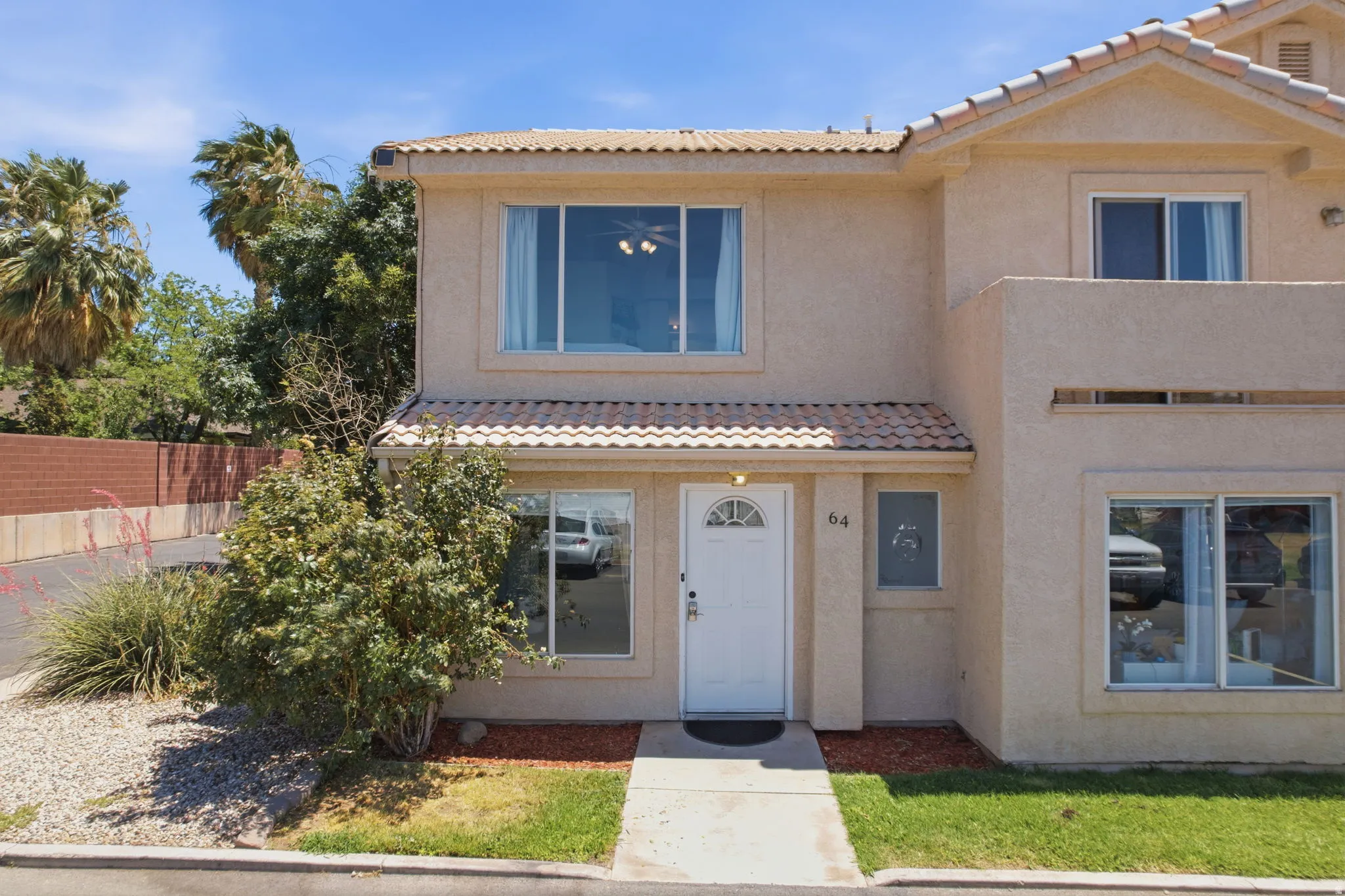 Two-story stucco residence with a tiled roof accent over the entry