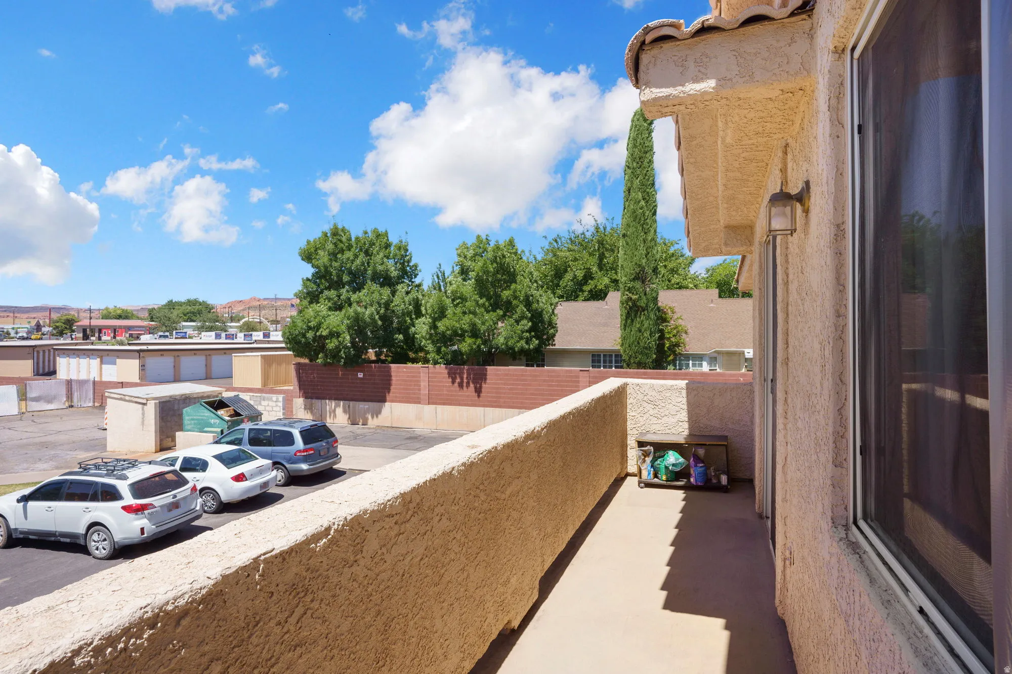 Private balcony featuring textured stucco walls and concrete flooring