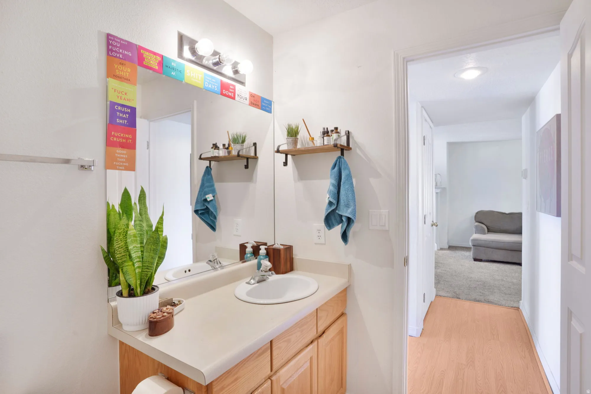 Bathroom vanity with a round undermount sink, a chrome faucet, and light-toned wood cabinetry