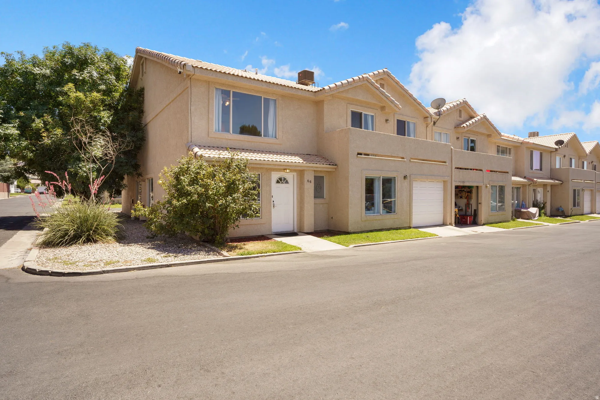 Townhome exterior featuring a stucco finish and Spanish-style roof tiles