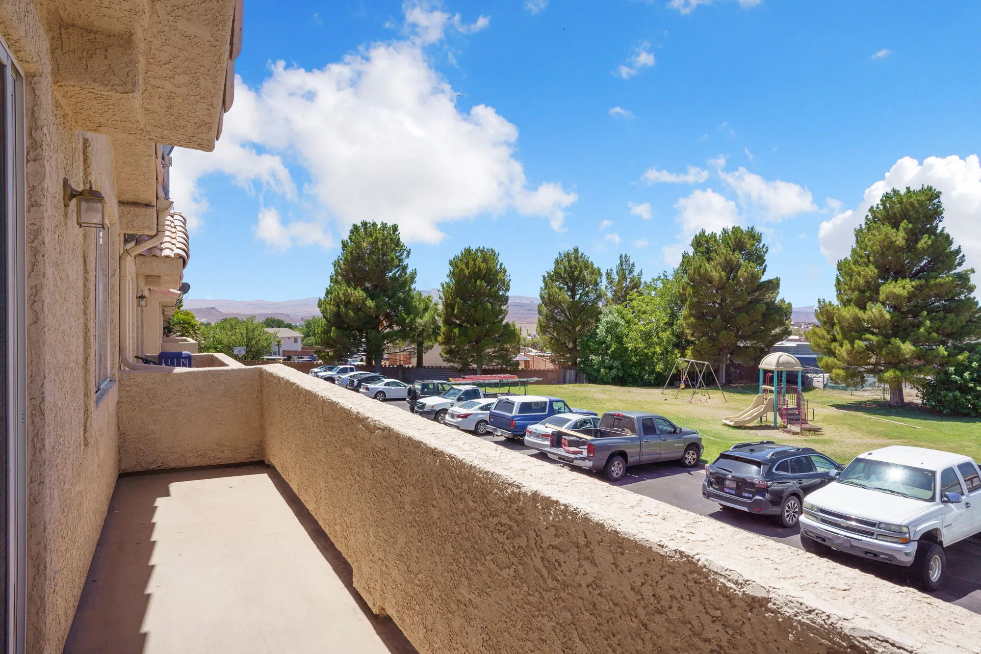 Private balcony with stucco exterior and concrete flooring