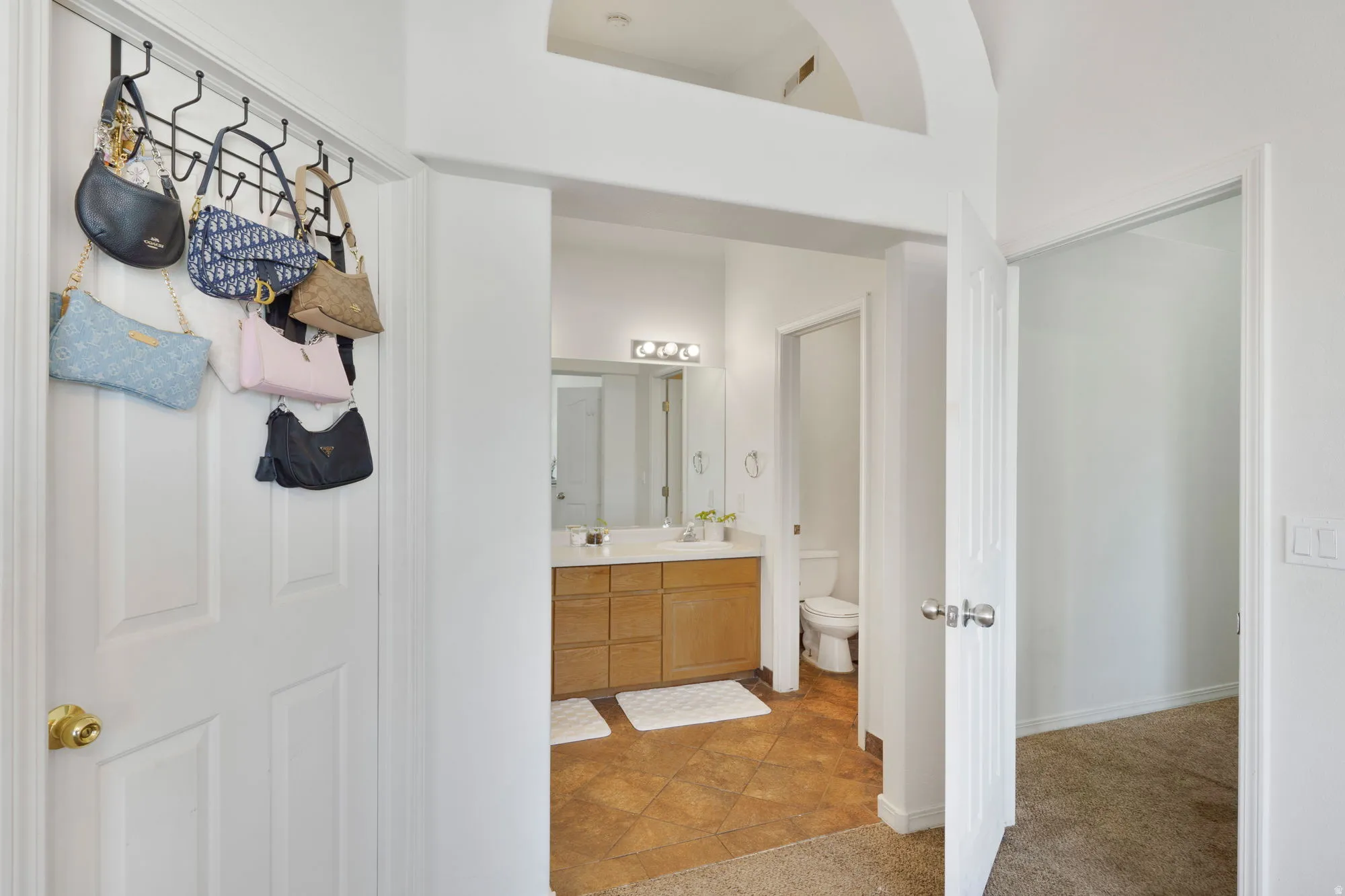 Bathroom featuring a dual vanity with a light wood-finish cabinet and a white countertop