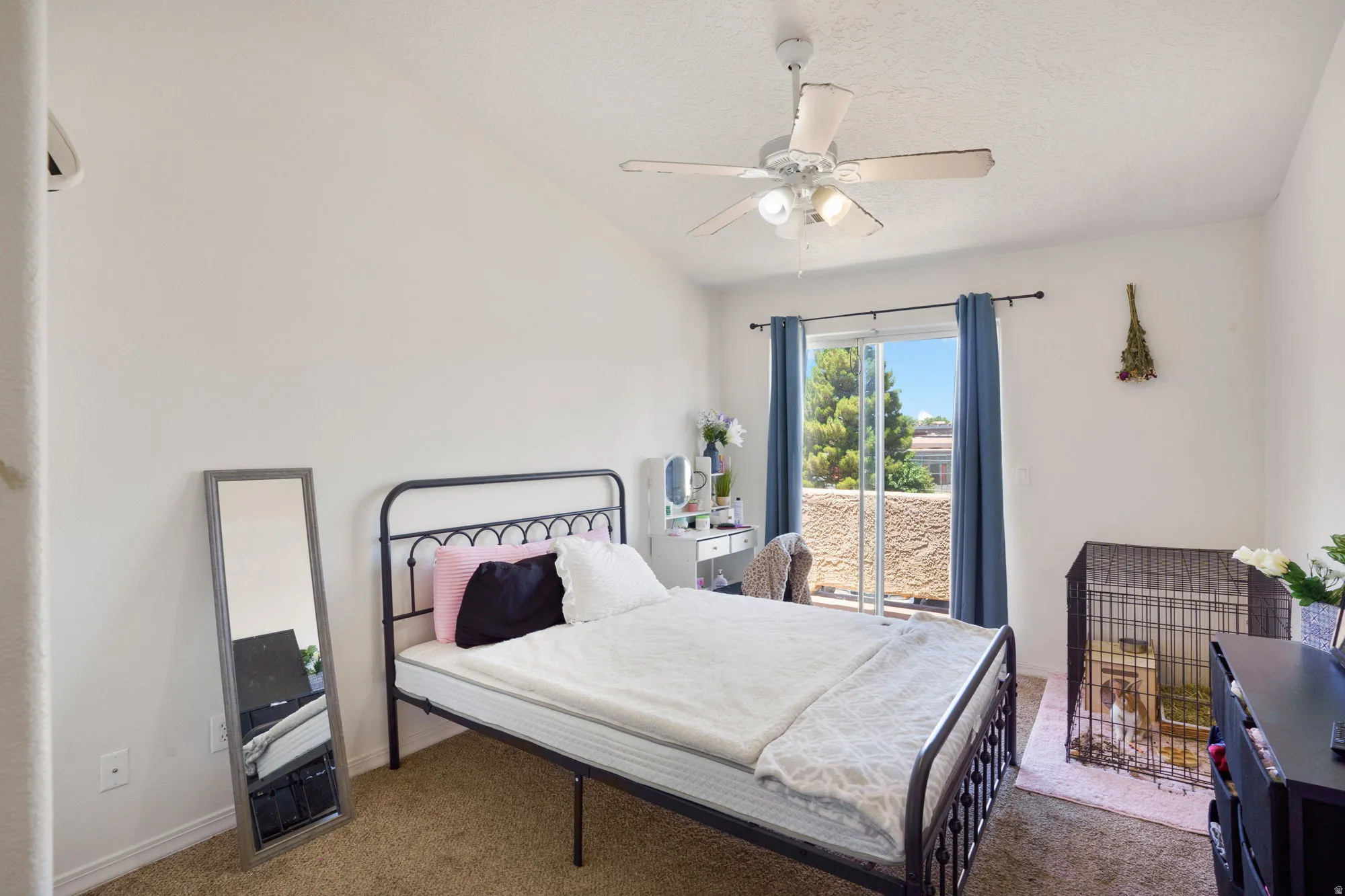Bedroom featuring a sliding glass door to an outdoor space, ceiling fan with integrated lighting, and neutral wall tones