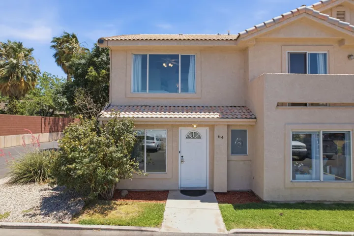 Two-story stucco residence with a tiled roof accent over the entry