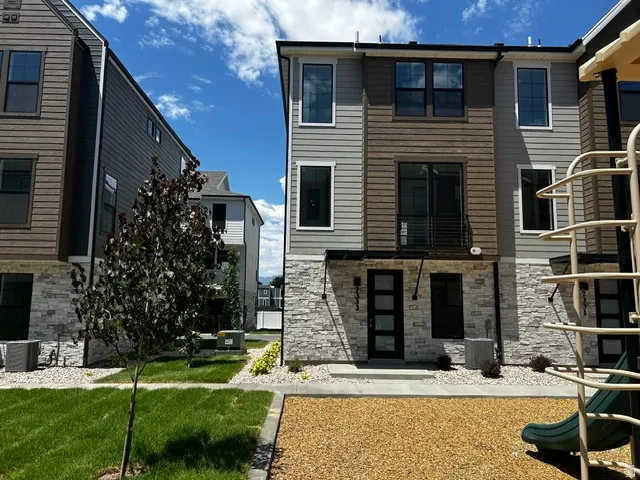 Modern townhome exterior featuring multi-toned siding and stone accents