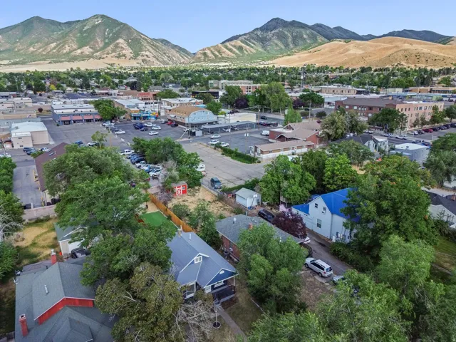 Aerial perspective showcasing the surrounding neighborhood with distant mountains