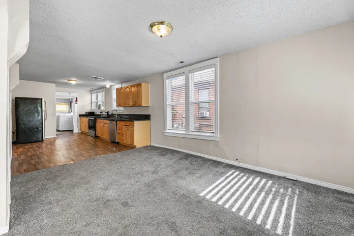 Living area featuring neutral-toned carpeting and multiple windows