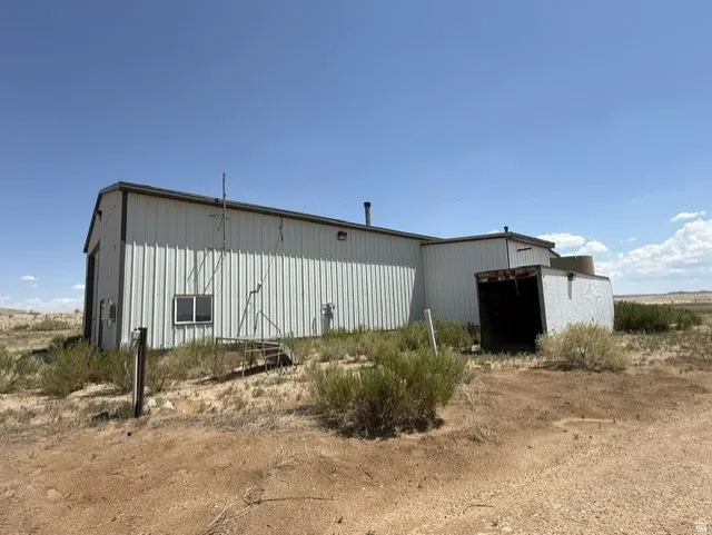 Industrial building featuring corrugated metal siding, a sloped roofline, and a smaller attached structure with an open entrance